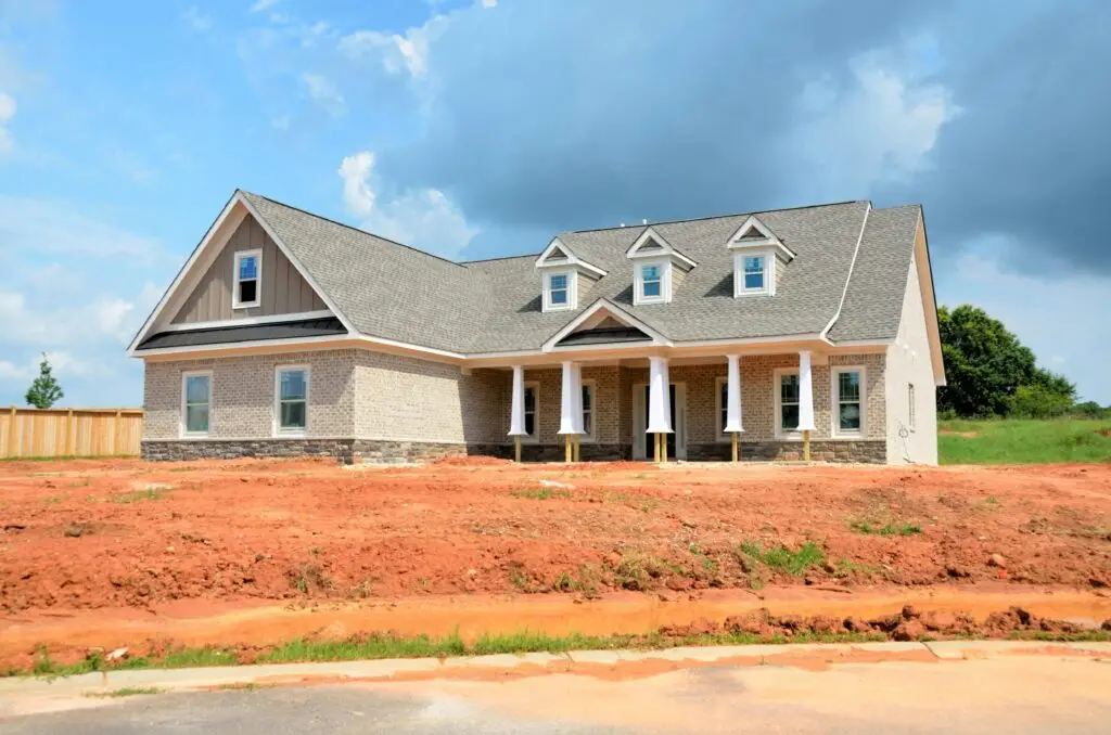 Brick modern family home under bright sky, showcasing new construction and architectural style.