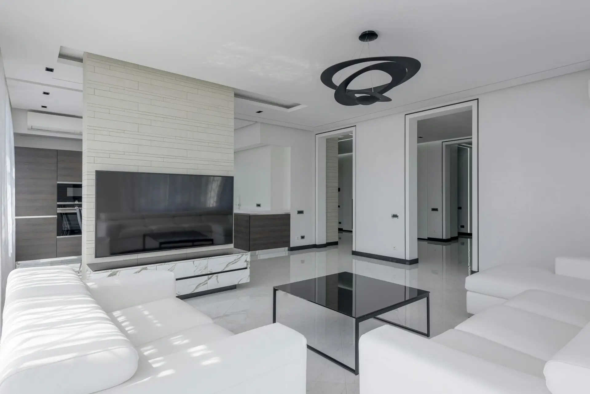 Bright and contemporary living room with sleek white furniture and modern decor.